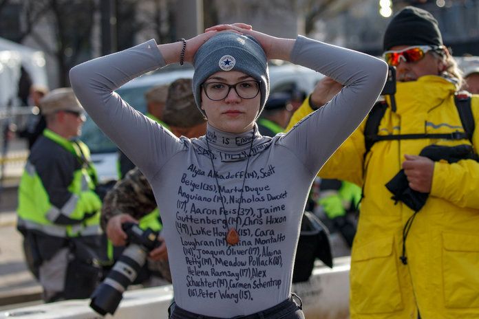 А protestor writes a message on her shirt rather than a poster. 
