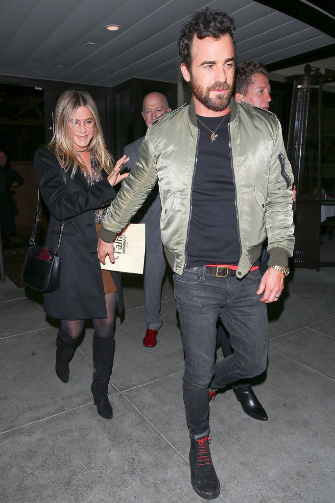 Дженифър Aniston and husband Justin Theroux enjoy a romantic date night out at The Palm restaurant in Beverly Hills. Jennifer has a huge smile on her face as she leaves with her man. Justin reaches back for her, and they hold hands as they head to the car
