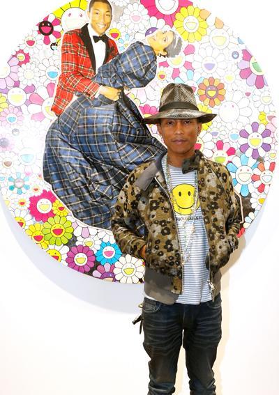 Фарел Williams posing front of the work of Takashi Murakami as he launches Galerie Perrotin's New Art Space with 