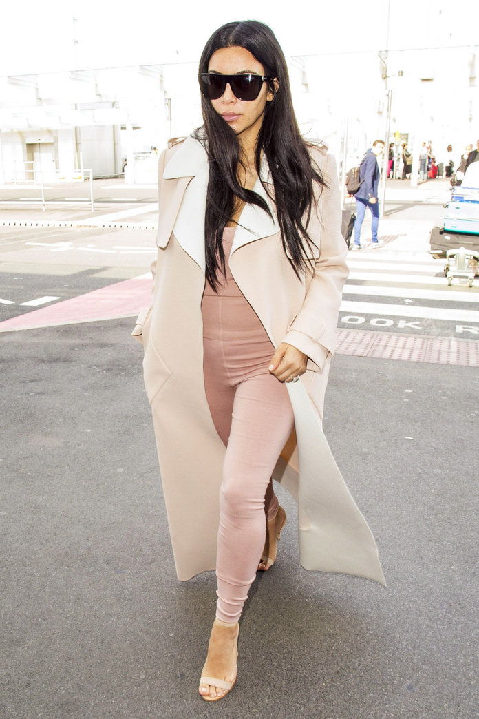 бременна Kim Kardashian catches a flight out of Heathrow Airport on June 29, 2015 in London, England. The reality star, dressed in a tight pink jumpsuit, a long cream coat and cream heels, spent the weekend watching her husband Kanye West perform at the G