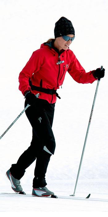 Pippa Middleton - red ski jacket, black snow pants, a black hat, and sporty shades